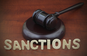 Sanctions, rules and laws concept. Judge gavel and word sanctions on wooden table.	