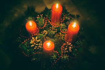 Close up of four red candles burning on advent wreath on evening. Merry Christmas, Advent crown...