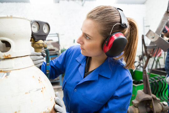 portrait of woman inspecting oxygen bottle