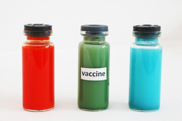 Three ampoules with a vaccine against the virus on a white background.