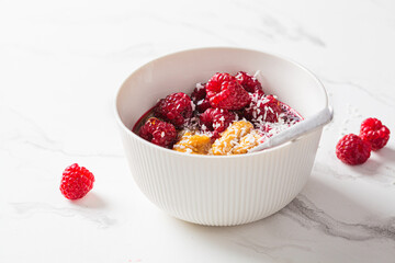 Chia pudding in bowl with raspberries, peanut butter and coconut. Vegan food concept.