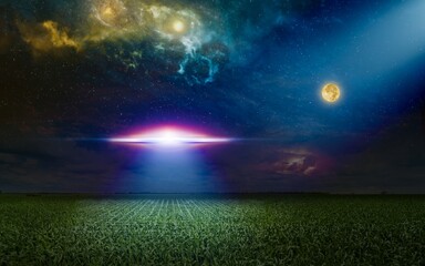 Scenic sci-fi image - ufo inspect green grass field with bright spotlight in dark night sky. Nebula and full moon in starry sky.