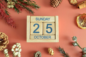 October 25, Cover design with calendar cube, pine cones and dried fruit in the natural concept.