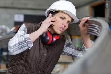 female engineer in factory examining threaded metal ring