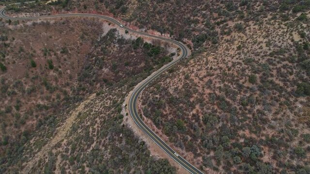 4K aerial following car up curvy mountain road in Prescott National Forest AZ