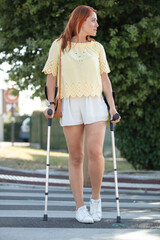 woman with crutches crossing the street