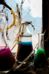Magic potions in bottles near old rustic window with backlight
