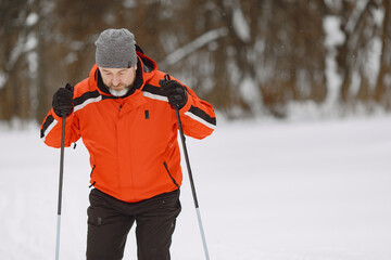 Senior man skiing cross-country in a forest