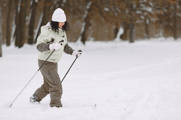 Senior woman skiing cross-country in a forest