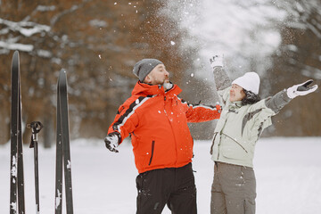 Senior couple skiing cross-country in a forest