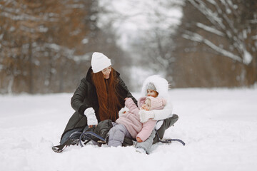 Mother and child in winter clothes play in winter park