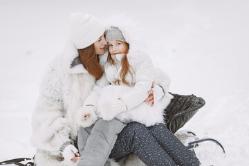 Obraz premium Mother and child in winter clothes play in winter park