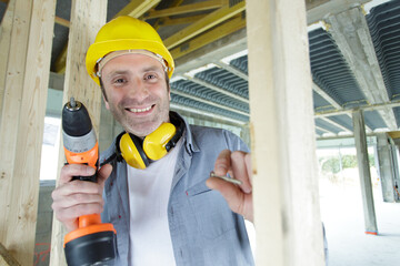 happy male builder holding a drill