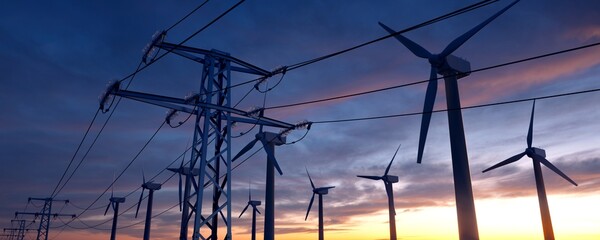 High voltage towers with sunset and wind turbines in the background. 