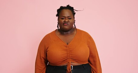 Black plump lady shows disgruntled face posing for camera