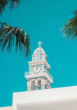mediterranean clock tower in greece with clear sky and palm leafs