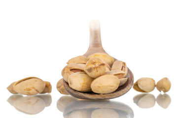 Several unpeeled pistachios with a wooden spoon, close-up, isolated on white.