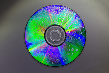 beautiful colours on a dvd disk with water droplets - stock photo
