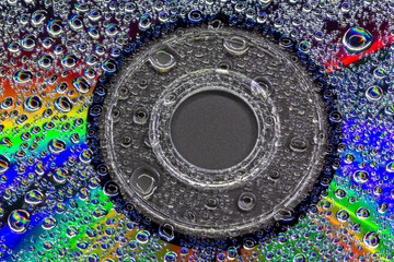 closeup colours of the rainbow through water droplets on a dvd disk - stock photo - stock photo