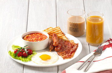 Traditional Full English breakfast, on a white background, fried eggs with fried bacon, sausages, white beans ,cherry tomatoes, horizontal, no people,