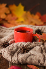 Obraz na płótnie Canvas Autumn postcard. A cup of coffee, a knitted warm scarf, autumn leaves.