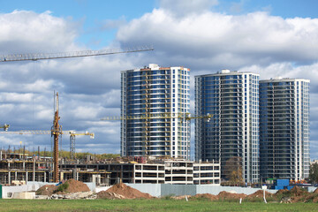 Construction of modern multi-storey buildings. Construction of a new city block. Buildings under construction and tower cranes.