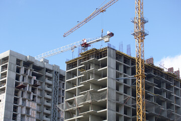 Construction of modern multi-storey buildings. Construction of a new city block. Buildings under construction and tower cranes.