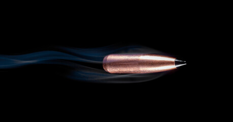 Bullet with smoke behind on a black background © Guy Sagi