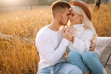 Romantic couple in love walking during autumn sunny day. Love story. Autumn style. Kiss and hugs.