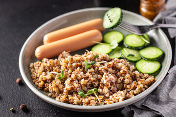 buckwheat porridge and sausages fresh cucumber salad diet meal snack on the table copy space food background rustic 