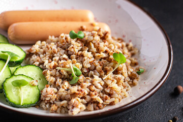 buckwheat porridge and sausages fresh cucumber salad diet meal snack on the table copy space food background rustic 