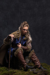 Obraz na płótnie Canvas Beautiful female viking woman warrior with ax and bow with arrows. Fantasy black concept