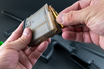 Loading 5.56mm assault rifle rounds into a magazine