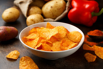 Paprika Potato Chips in white bowl on rustic background