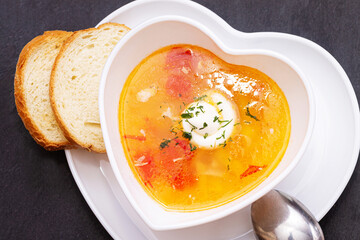 Delicious chicken soup with tomatoes close-up. Dinner.