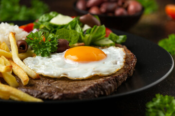 Portugal dish Bitoque made from beef steak with a fried egg, rice, french fries and vegetables