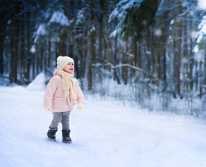 Fototapeta na wymiar Happy girl in a snowy forest