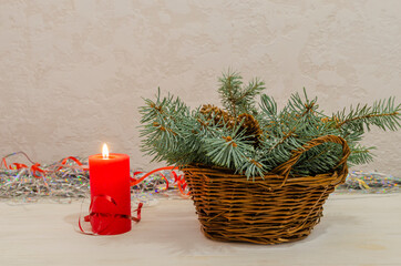 Christmas candle and wicker basket with christmas tree branch