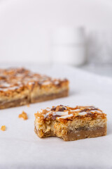 Close up of a coconut macaroon cookie bars squares with a bite out