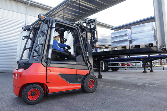Forklift driver unloading lorry.