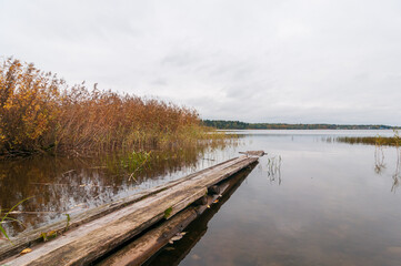 Naklejka premium Beautiful landscape with a view of the lake and wooden footbridge, autumn
