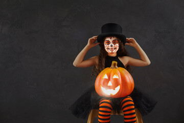 Child having fun on Halloween. Portrait of kid in spooky costume. Happy girl with beautiful skull...