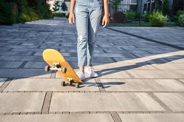 Cropped image of little girl kicking up skateboard