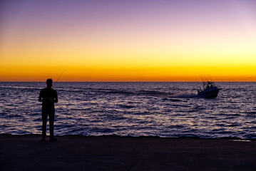 Lake Michigan fisherman & returning boat at dusk