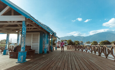 Tourist man with hat walking on the tourist pier of the city of La Ceiba, Atlantida, Honduras.