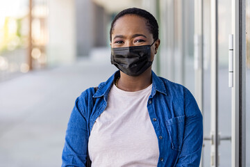 Masked woman - protection against influenza virus. African - American woman wearing mask for...