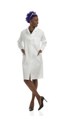 Beautiful Black Woman In Lab Coat Is Standing With Hands In Pockets And Looking Away. Full Length, Isolated.