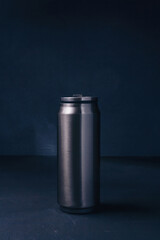 Metallic thermos bottle or thermo flask for hot or cold beverage on dark background. Eco friendly, zero waste. Vertical shot, copy space