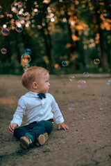 Cheerful child boy rejoices with soap bubbles.