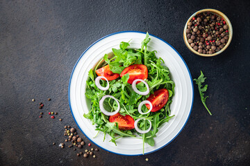 arugula and tomato salad vegetable in a plate fresh portion ready to eat meal snack on the table copy space food background rustic. top view keto or paleo diet veggie vegan or vegetarian food